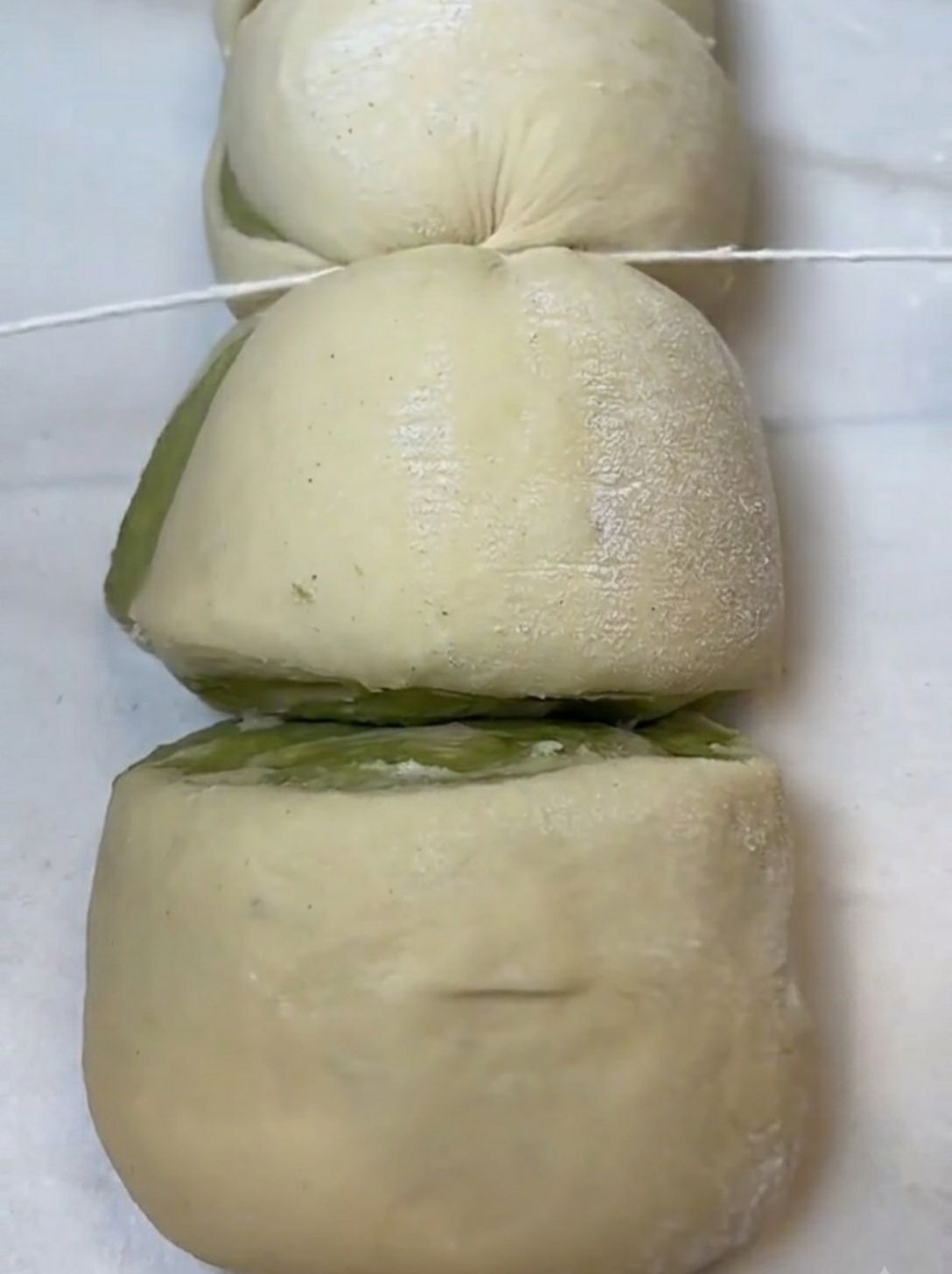 Cutting the rolled brioche log into pieces with kitchen twine