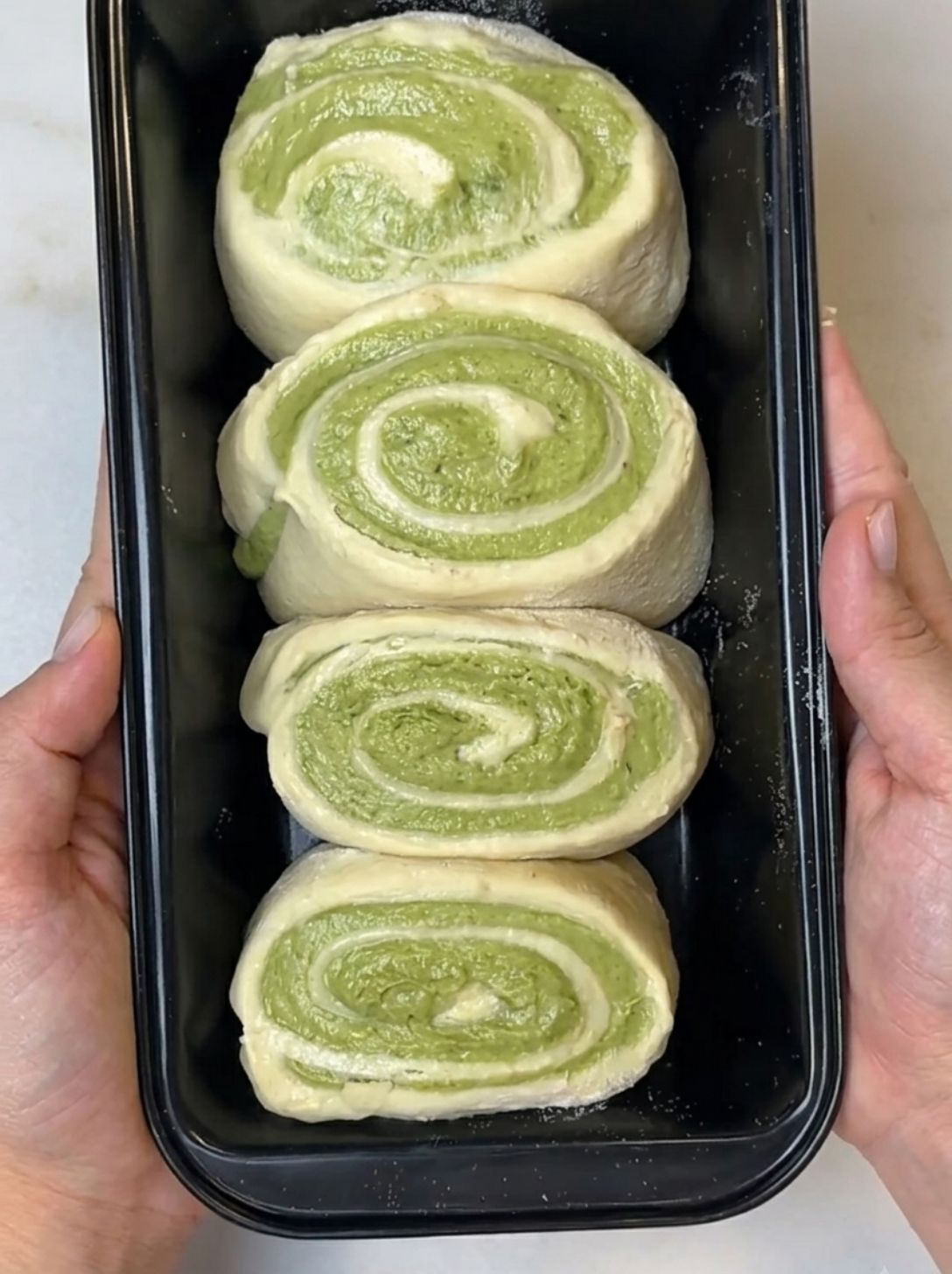 Brioche pieces proofing swirl-side-up in the loaf tin