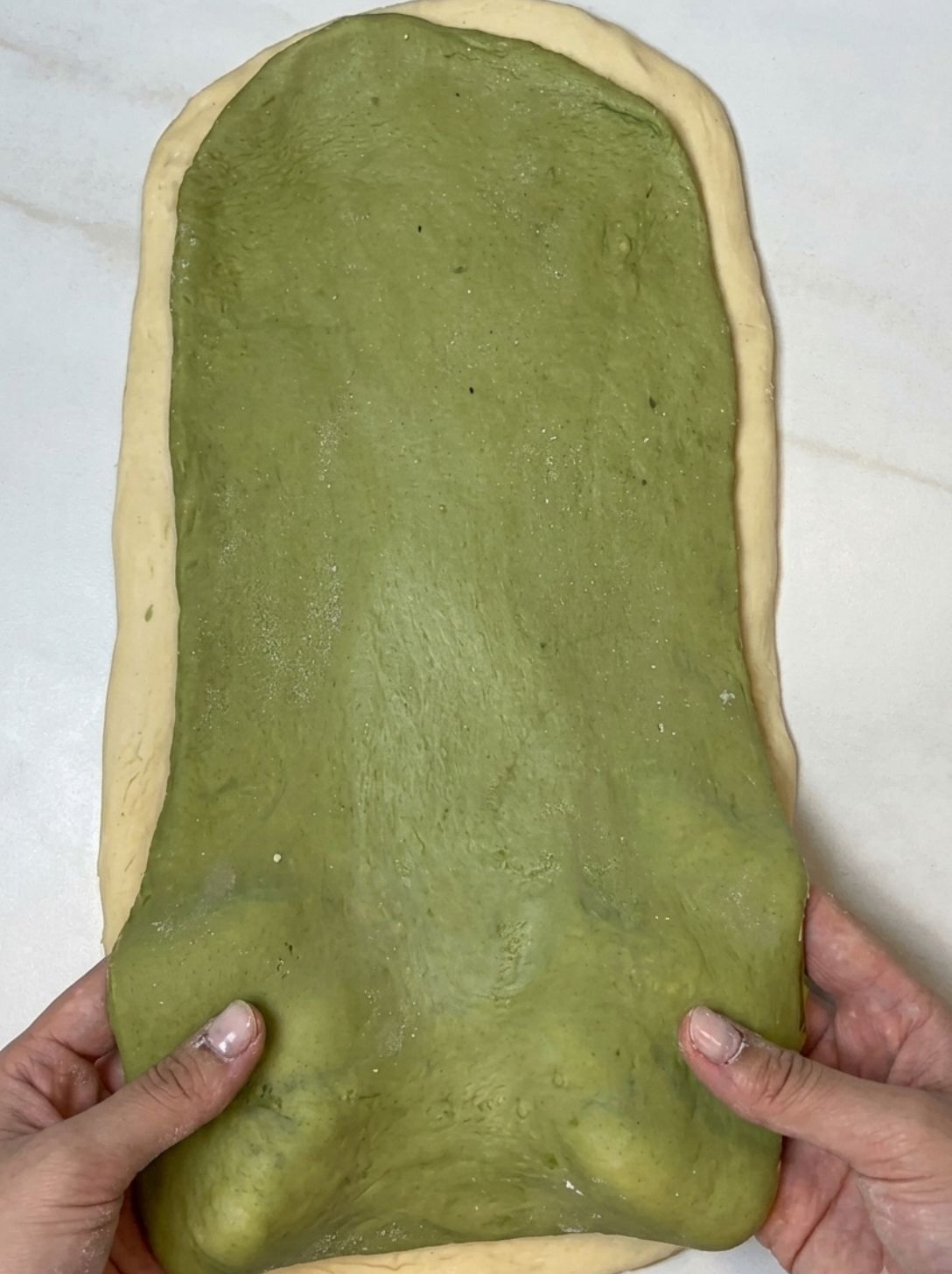 Matcha dough sheet placed on top of the plain dough sheet