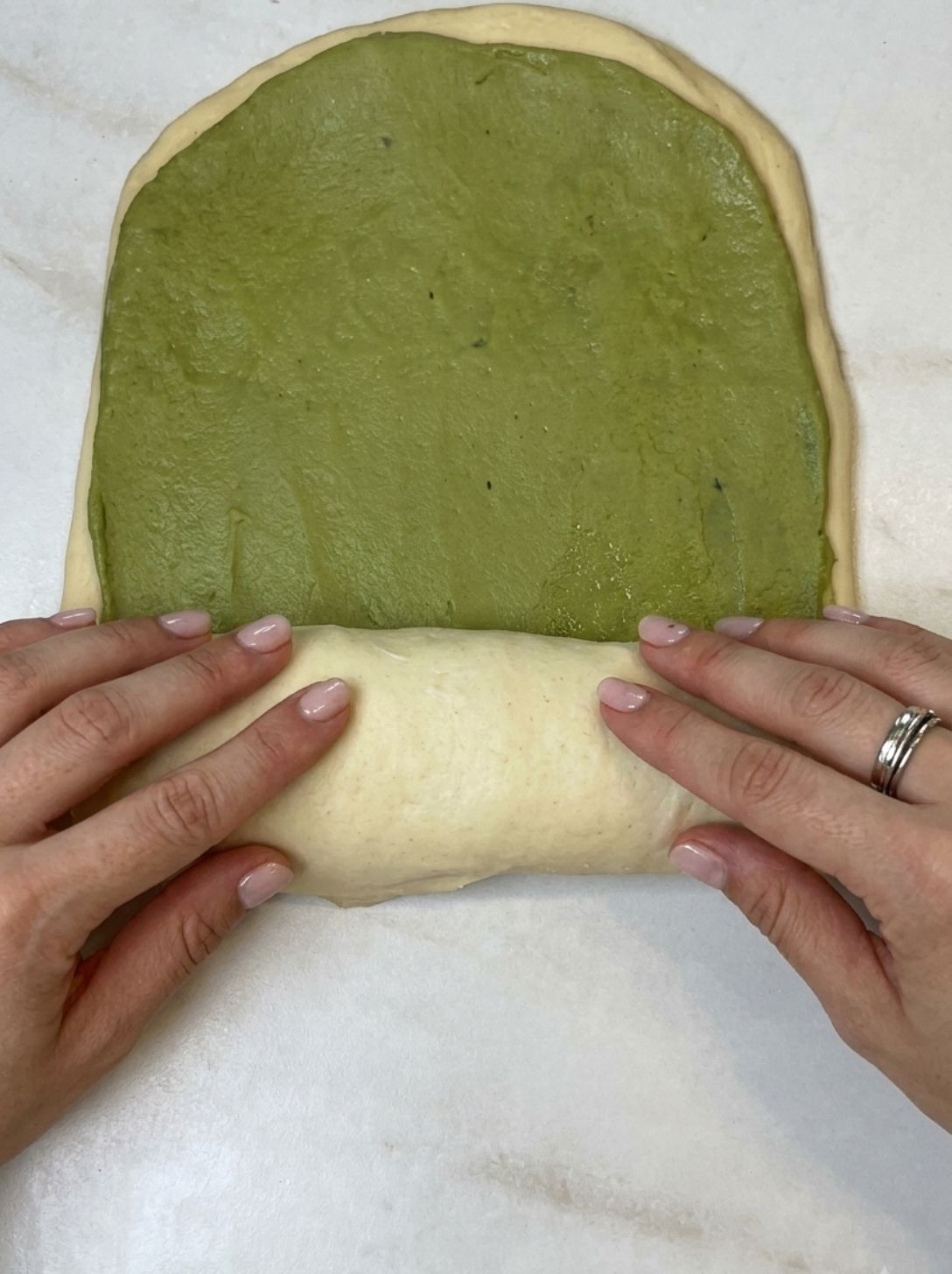Rolling pin pressing the two stacked dough layers together